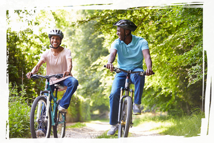 Two people cycling through forest